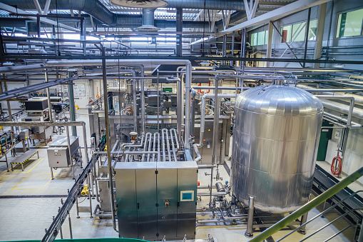 Modern brewery production line. Large vat for beer  fermentation and maturation, pipelines and filtration system.